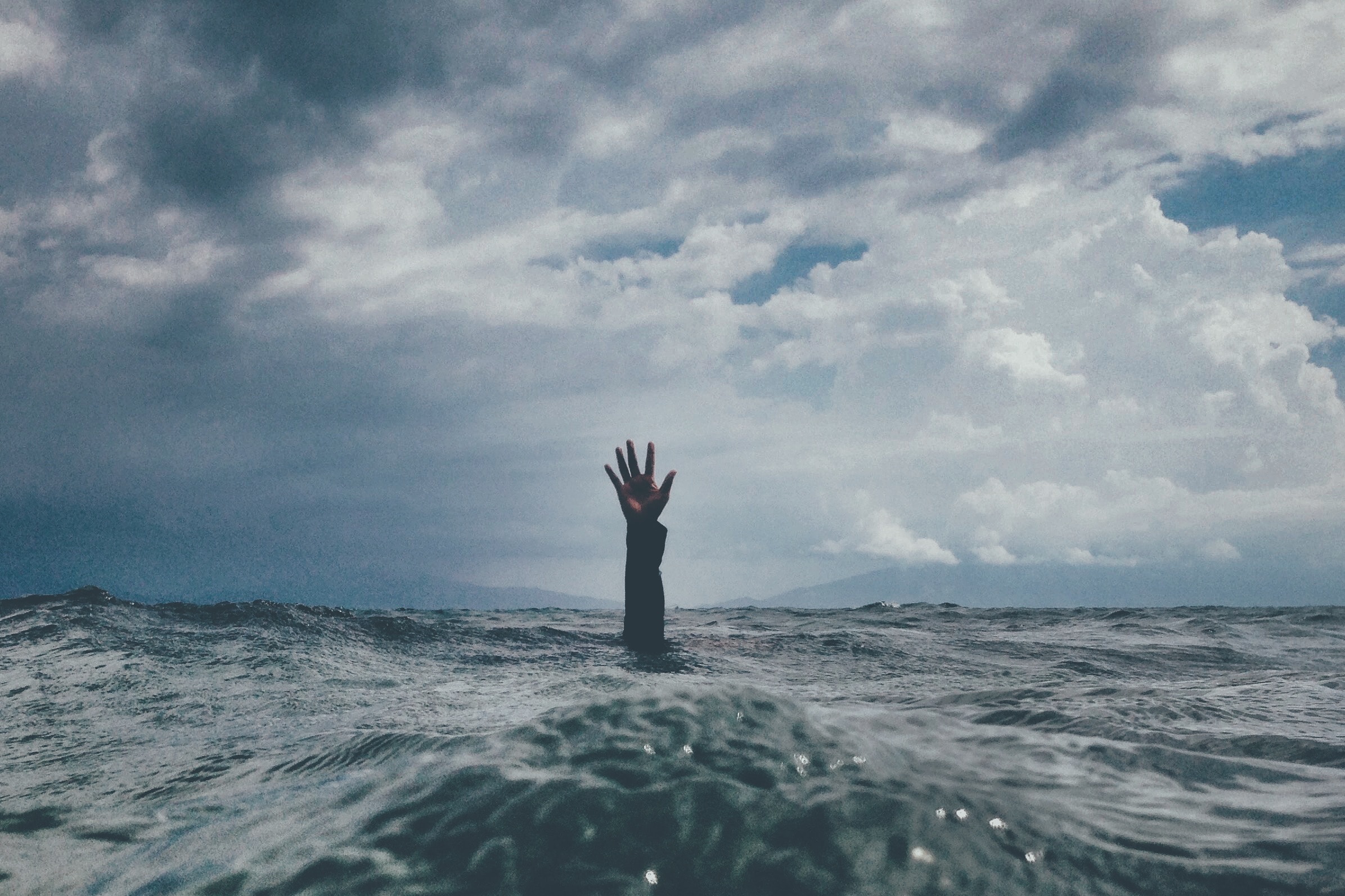 Hand raising above water